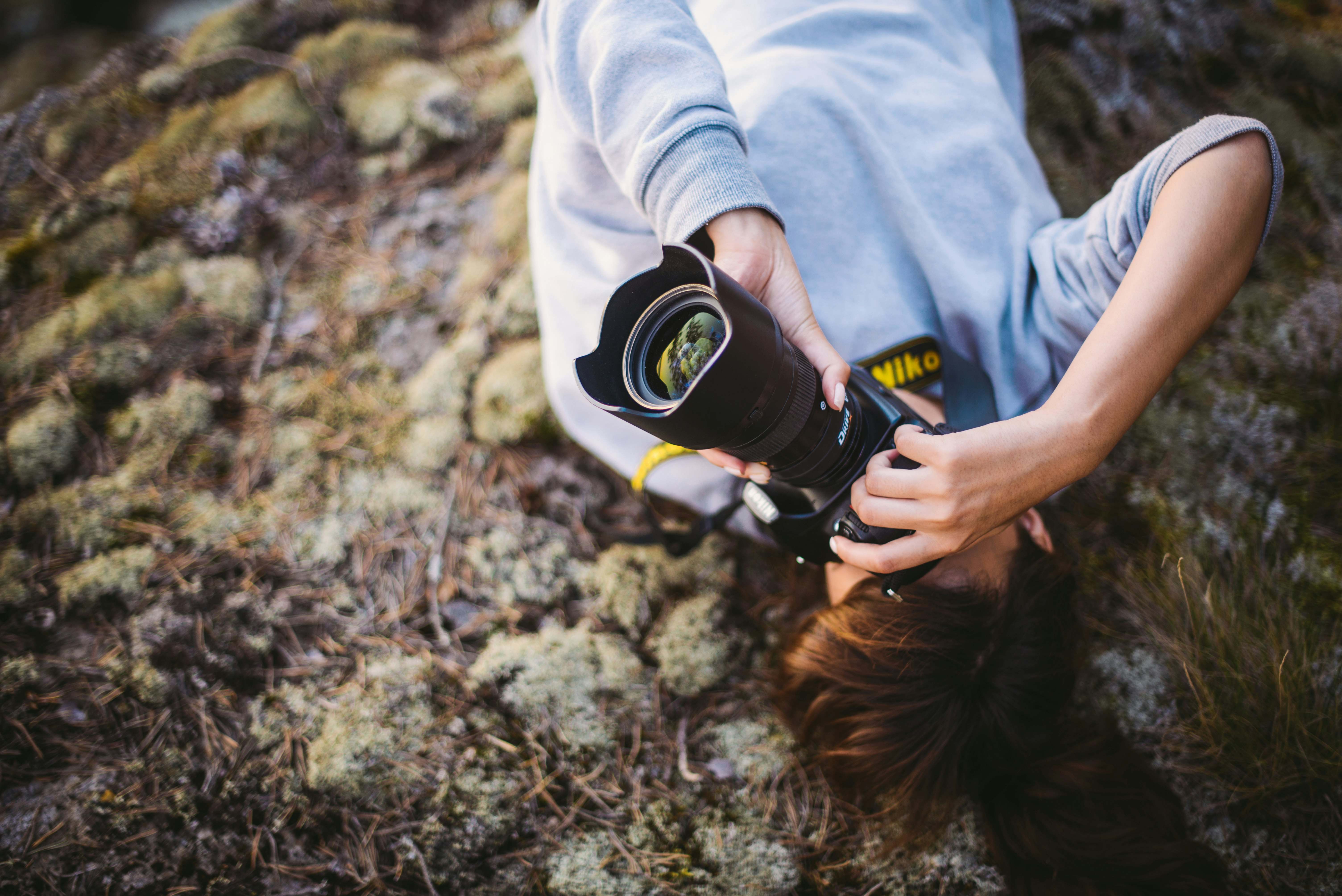 person in white long sleeve shirt holding black and yellow bottle